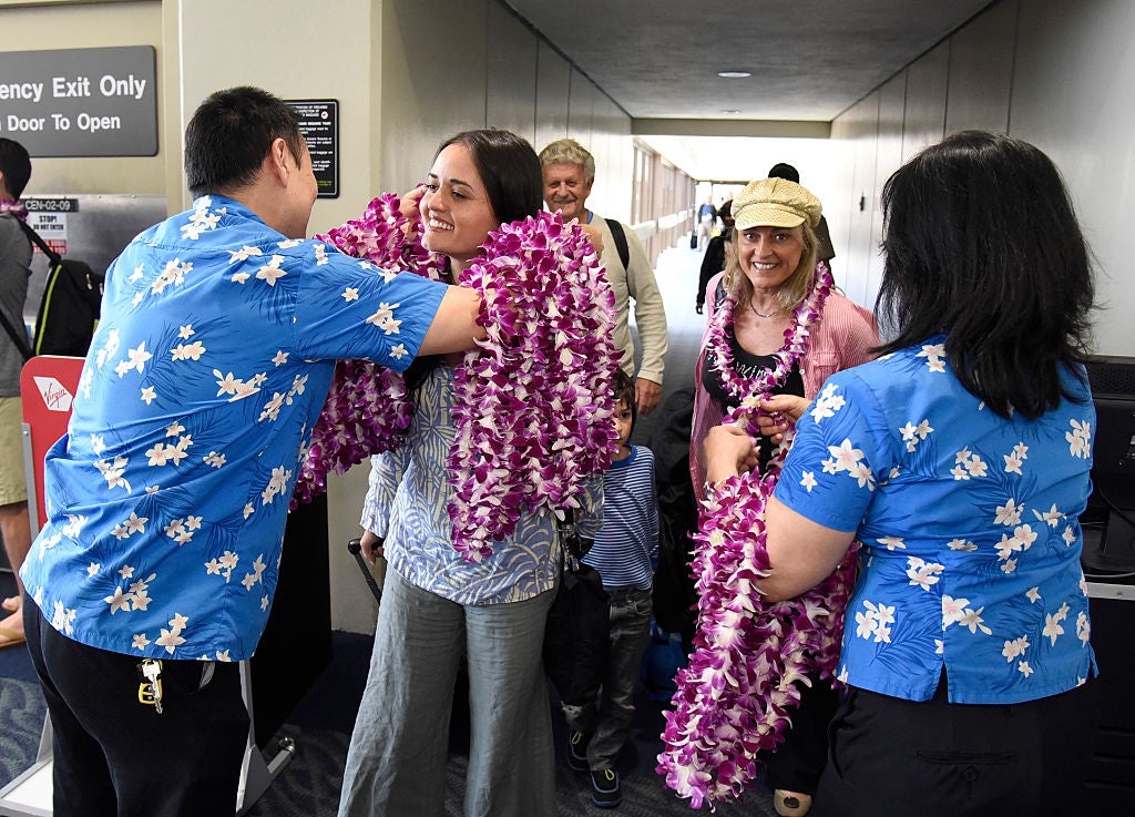 People being greeted with lei at a Hawaii airport.